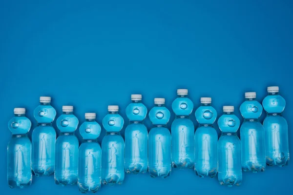 Vista Superior Botellas Agua Plásticas Dispuestas Aisladas Azul Con Espacio — Foto de Stock