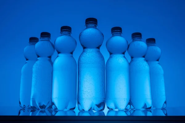 Toned Image Plastic Bottles Water Row Neon Blue Background — Stock Photo, Image