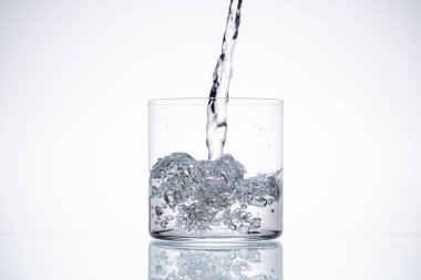water pouring in glass on white background with backlit and copy space clipart
