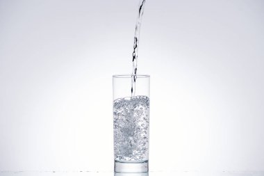 water pouring in drinking glass on white background with backlit clipart