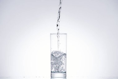water pouring in glass on white background with back light and copy space clipart