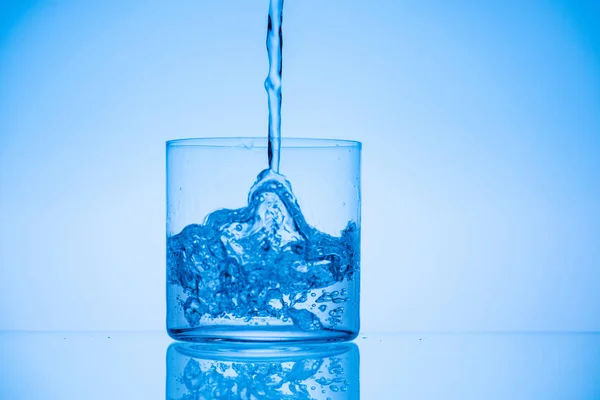 Toned Image Water Pouring Glass Blue Background — Stock Photo, Image