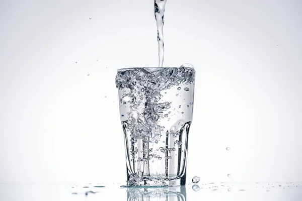 Water Pouring Full Glass White Background Backlit Splashes — Stock Photo, Image