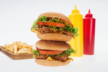 lezzetli tavuk Burger patates kızartması ve ketçap ve hardal beyaz izole şişe yakınındaki seçici odak