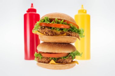 lezzetli tavuk Burger şişe ketçap ve hardal beyaz izole yakınındaki seçici odak