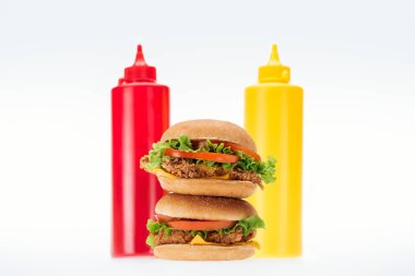 lezzetli tavuk Burger şişe ketçap ve hardal beyaz izole yakınındaki seçici odak