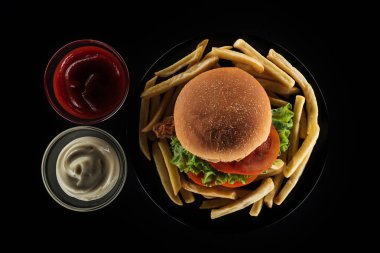 lezzetli Fransız kızartması ve mayonez, ketçap siyah izole yakınındaki tavuk burger Üstten Görünüm