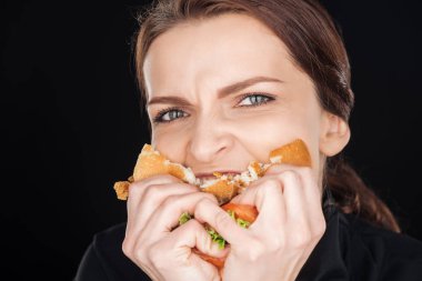 duygusal kadın siyah izole kamera bakarken lezzetli tavuk burger yiyen