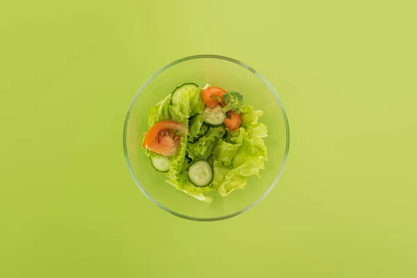 top view of chopped salad in glass bowl isolated on green