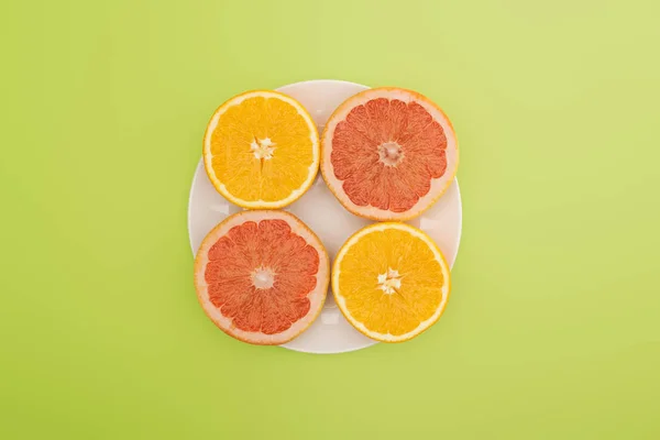 Pohled Shora Plátky Pomeranče Grapefruity Bílé Plotně Izolované Zelené — Stock fotografie