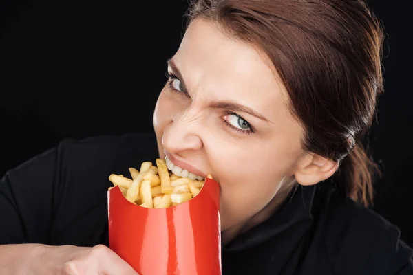 Emocjonalne Kobieta Jedzenie Smaczne Frytki Patrząc Kamery Czarnym Tle — Zdjęcie stockowe