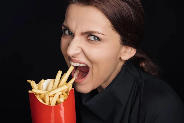 Donna Affamata Mangiare Gustose Patatine Fritte Isolate Sul Nero — Foto Stock