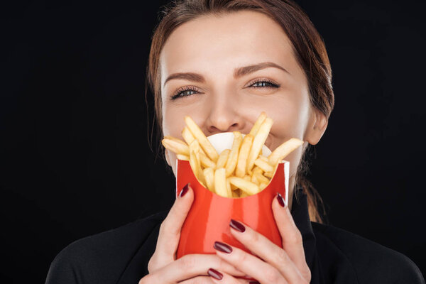 woman covering face with french fries isolated on black