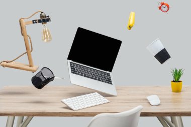 laptop ile boş bir ekran ve gri izole işyerinde havada levitating Kırtasiye