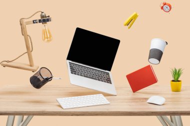 laptop ile boş bir ekran ve ahşap Resepsiyon üzerinde bej izole üzerindeki hava içinde ileti örneği levitating
