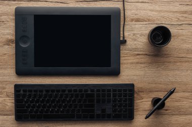 ahşap masa üzerinde siyah grafik tablet, grafik kalem, kablosuz bilgisayar klavye ve boş Kupası Üstten Görünüm