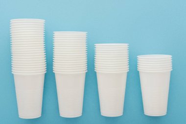 düz lay ile kopya alanı mavi zemin üzerine beyaz plastik bardak 