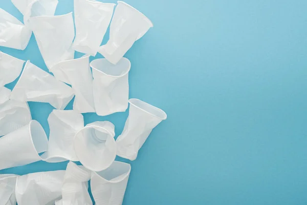 Draufsicht Auf Weiße Und Zerknüllte Plastikbecher Auf Blauem Hintergrund Mit — Stockfoto