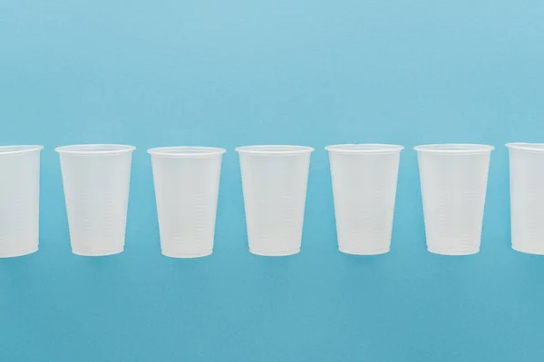 Flat Lay White Plastic Cups Isolated Blue Copy Space — Stock Photo, Image