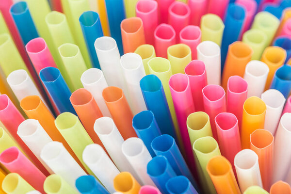 close up of colorful and bright plastic straws with copy space 