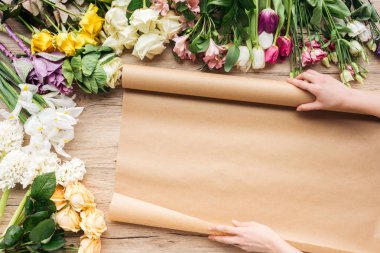 Çiçekçi Kraft kağıt ve renkli çiçeklerle görünümünü ahşap yüzeyde kırpılmış