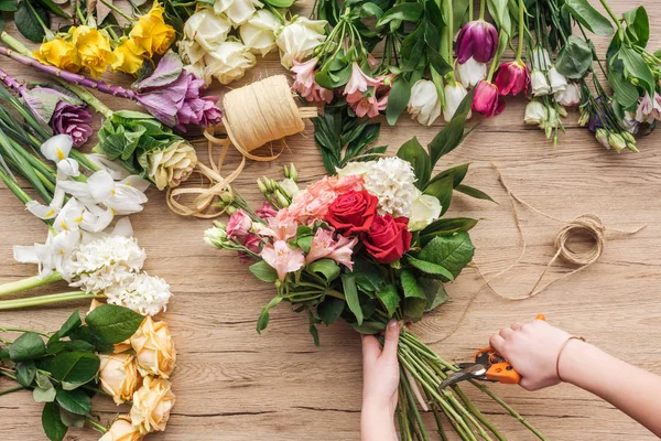 Teilansicht Des Blumenhändlers Der Blumenstrauß Hält Und Blütenstiele Auf Holzoberfläche — Stockfoto