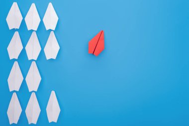 Flat lay with white and red paper planes on blue clipart