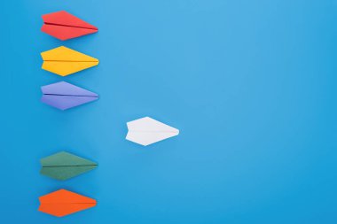 Renkli kağıt uçaklar mavi yüzeyi düz yatırın