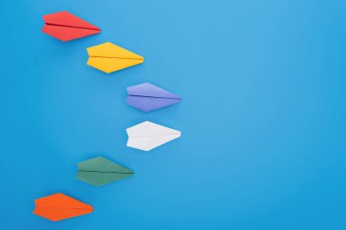 Renkli kağıt uçaklar mavi yüzeyi düz yatırın
