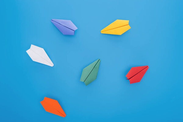 Плоский лежал с красочными бумажными плоскостями на голубой поверхности
