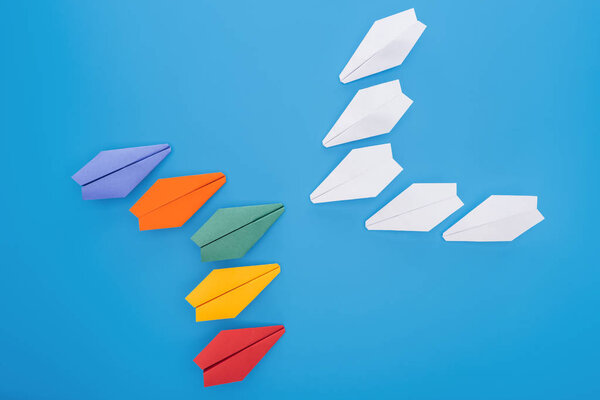 Плоский лежал с красочными бумажными плоскостями на голубой поверхности
