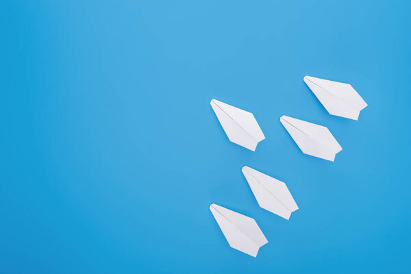 Плоская с белыми бумажными плоскостями на голубой поверхности
