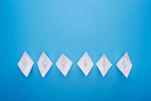 Плоский лежал с белыми бумажными лодками на голубой поверхности
