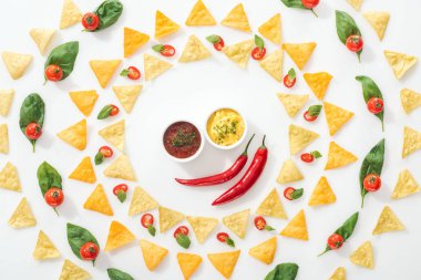 top view of tasty nachos, sauces and sliced chili peppers with basil and cherry tomatoes  clipart