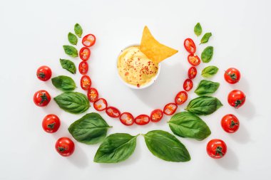 kesme Chili Peppers üst görünümü, fesleğen yaprakları, sos ve olgun kiraz domates nachos