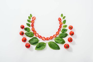 Beyaz arka planda kesilmiş Chili Peppers, fesleğen yaprakları ve olgun kiraz domates üst görünümü 