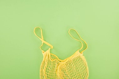 top view of yellow empty string bag on light green background clipart