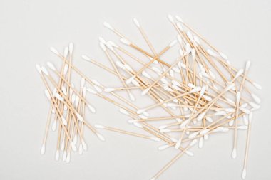 top view of scattered cotton swabs on grey background clipart