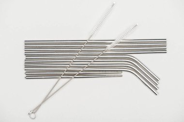 Paslanmaz çelik pipetler ve gri renkte izole edilmiş temizlik fırçalarının üst görünümü