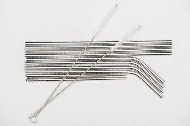 top view of stainless steel straws and cleaning brushes isolated on grey clipart