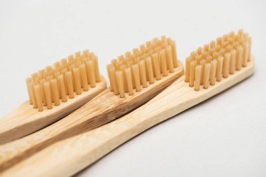 close up view of organic bamboo toothbrushes on grey  clipart