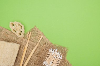 Bambu diş fırçaları, organik Loofah, pamuk bezlerden ve açık yeşil arka planda kahverengi demir