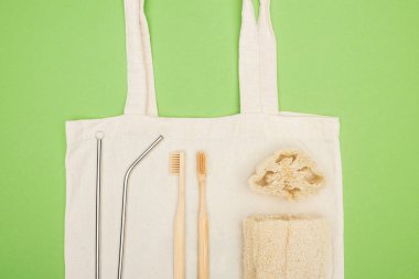 stainless steel straws, organic bamboo toothbrushes and loofah on cotton bag clipart