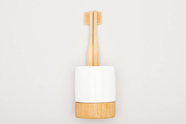 bamboo toothbrushes in stand on grey background