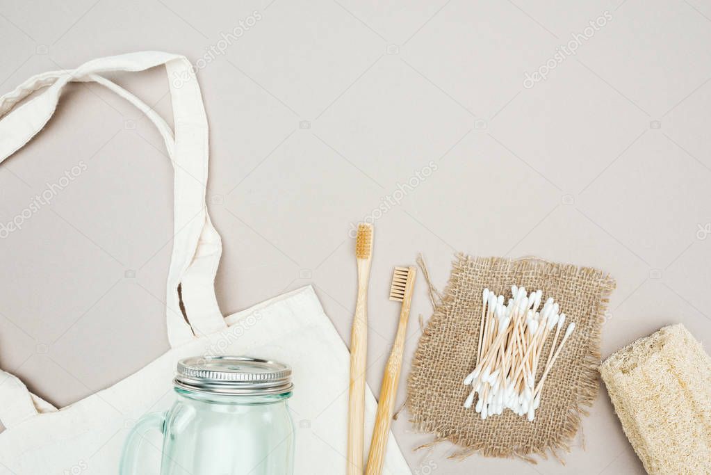 wooden toothbrushes, organic loofah, cotton swabs, sackcloth, glass jar and white cotton bag