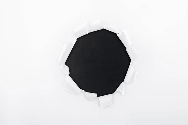Buraco Irregular Papel Branco Texturizado Sobre Fundo Preto — Fotografia de Stock