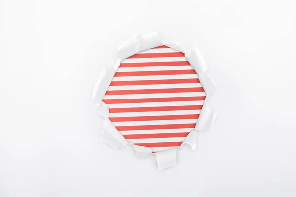 Buraco Irregular Papel Branco Texturizado Sobre Fundo Listrado Vermelho — Fotografia de Stock