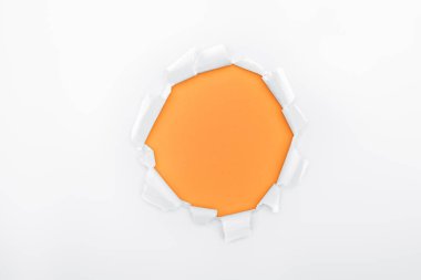 ripped hole in textured white paper on orange background  clipart