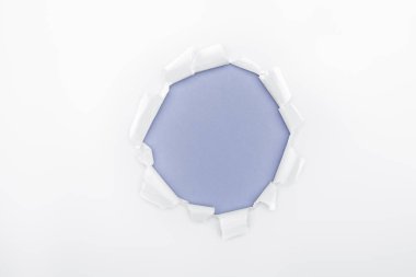 ripped hole in white textured paper on blue background  clipart