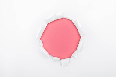ragged hole in white textured paper on pink background  clipart